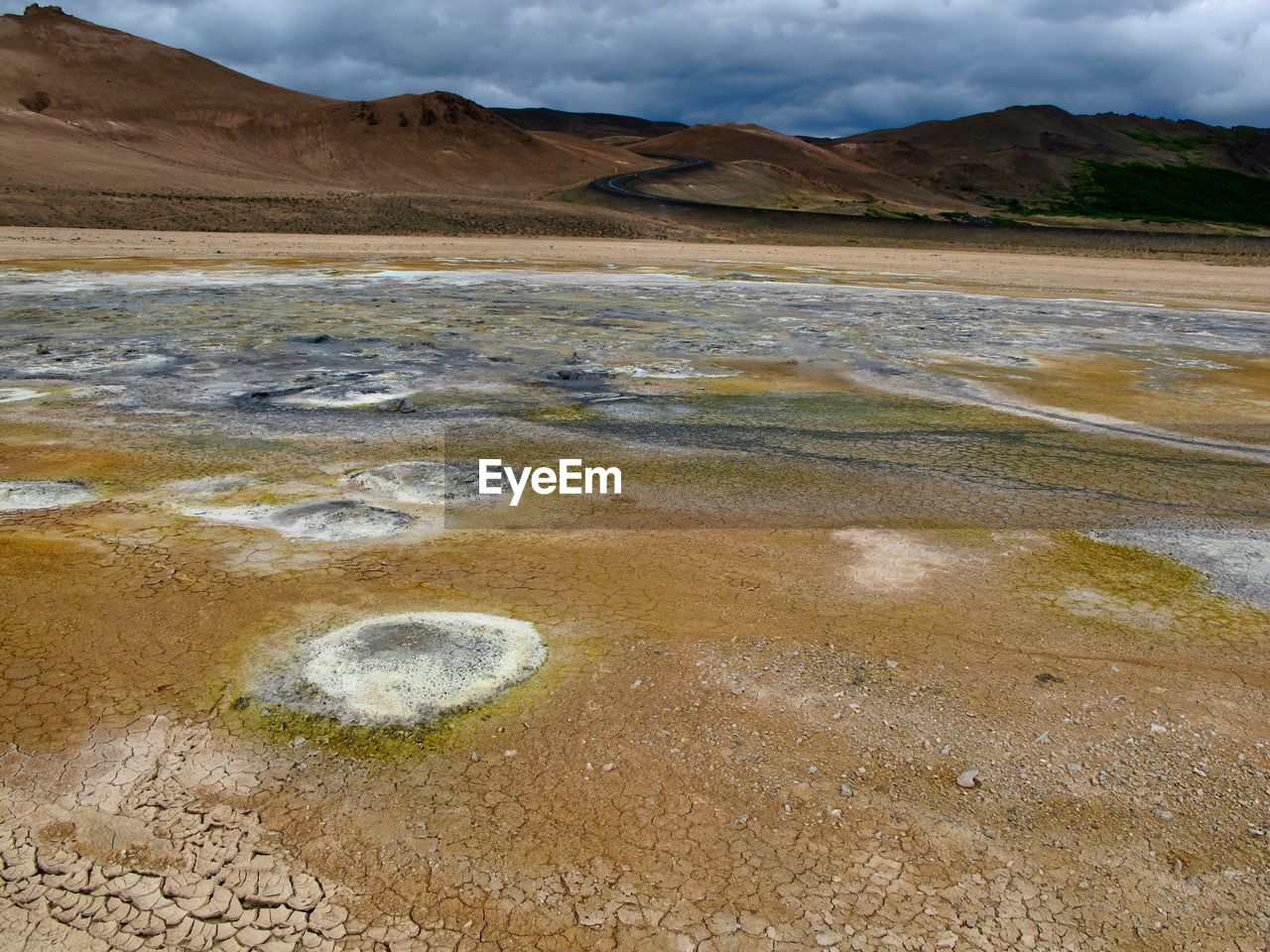 Scenic view of strokkur geyser and mountains against sky