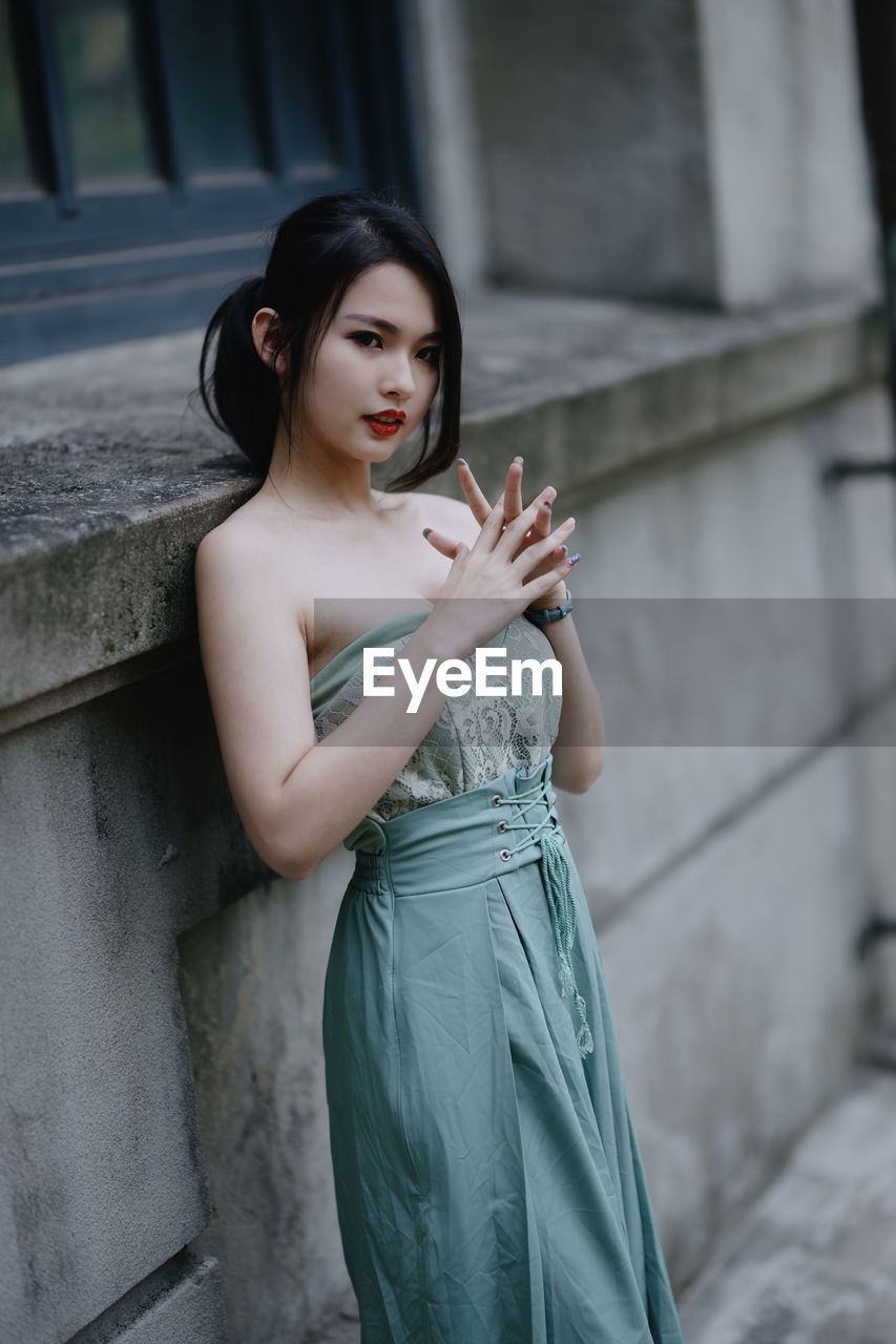 portrait of young woman looking away while standing outdoors