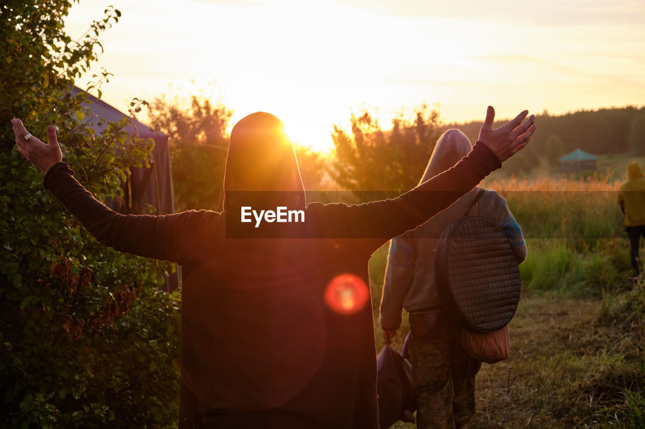 Dawn. the man stretched out his hands towards the sun, viewed from the back. nature, summer.