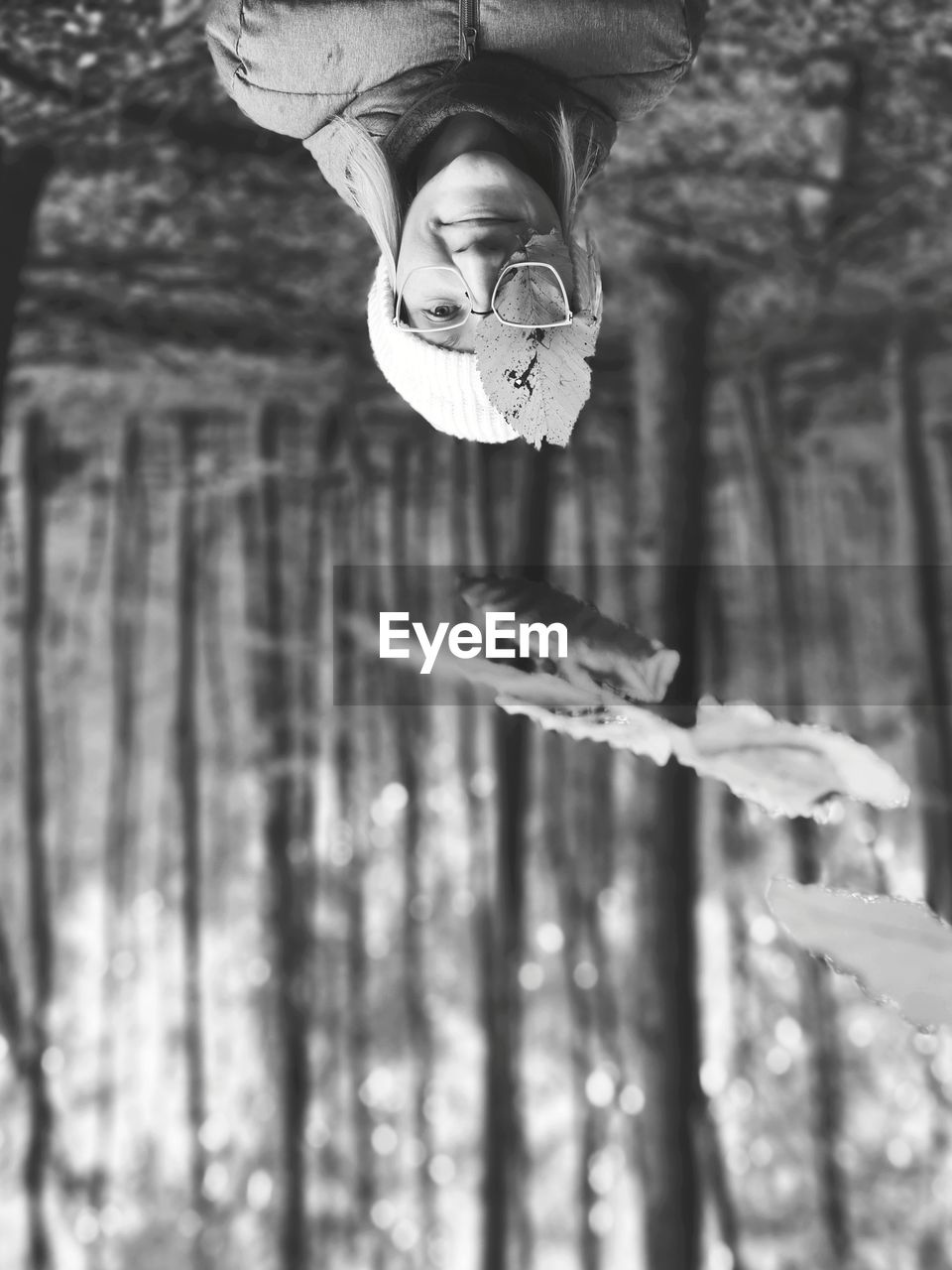 Upside down image of woman in forest during winter