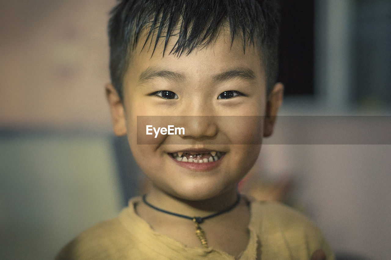 Close-up portrait of smiling boy at home