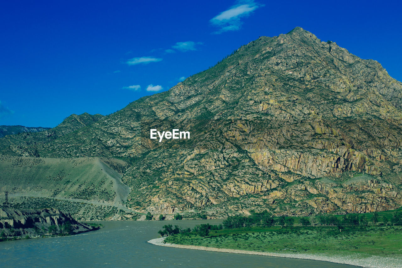 Scenic view of mountains against blue sky