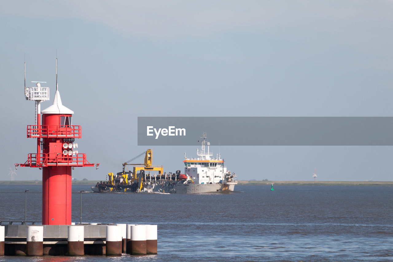 Lighthouse and a ship at the lock kiel canal in brunsbuettel