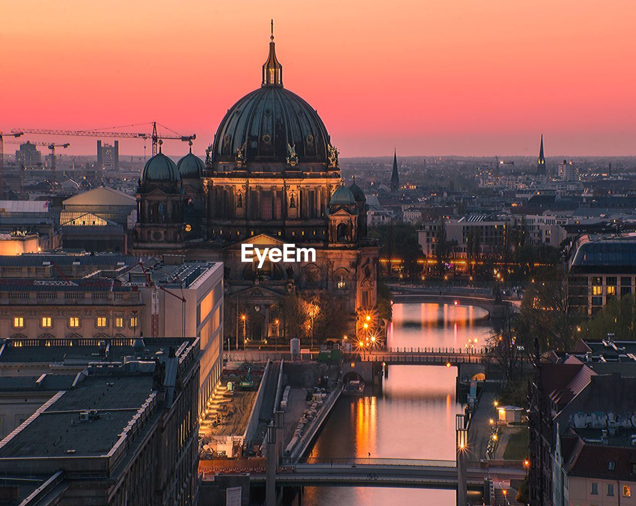 Illuminated buildings against sky at sunset