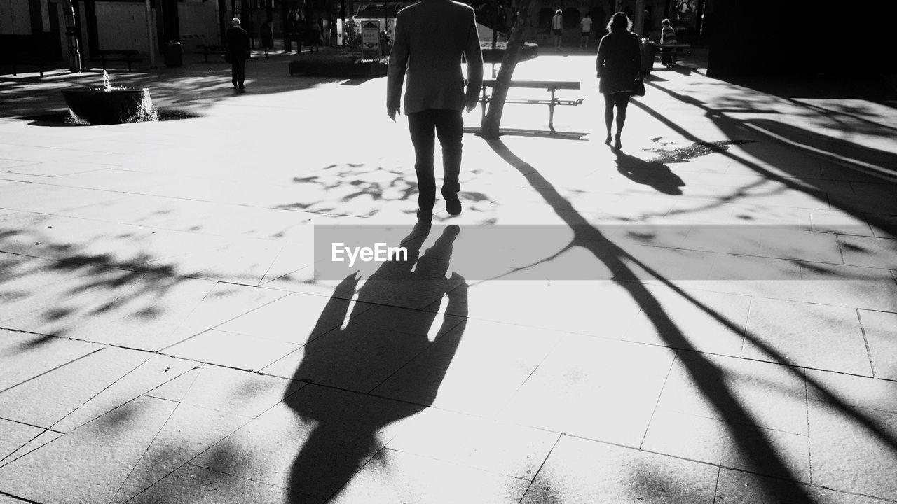 Rear view of man and woman walking on street