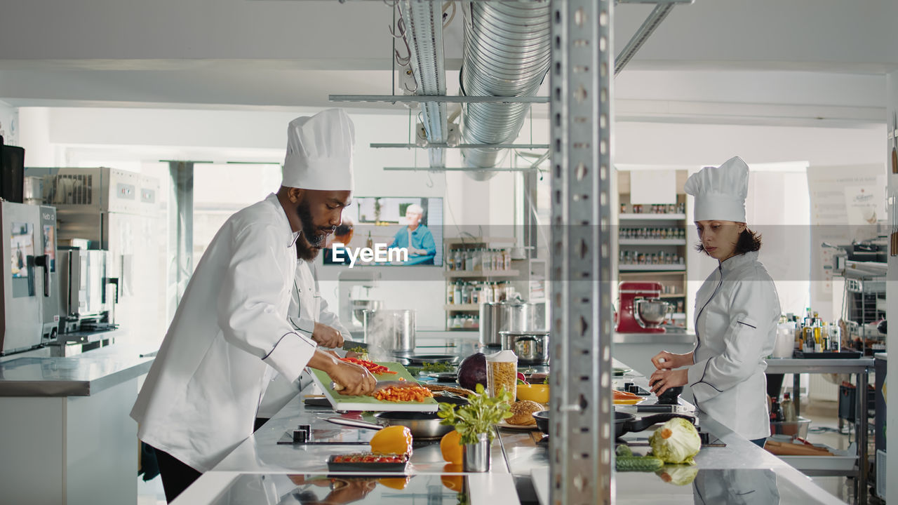 Chef working with trainee in kitchen