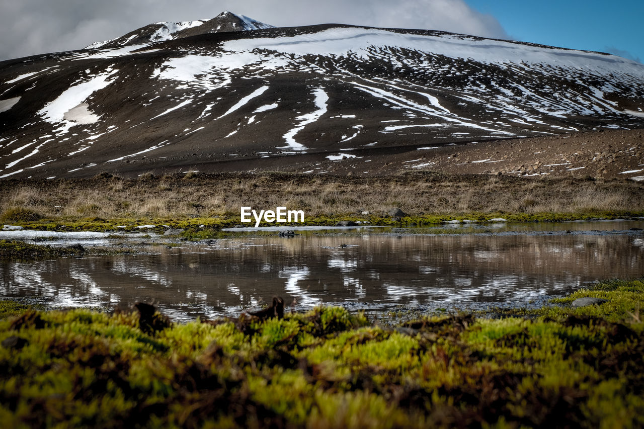 Scenic view of lake against sky during winter