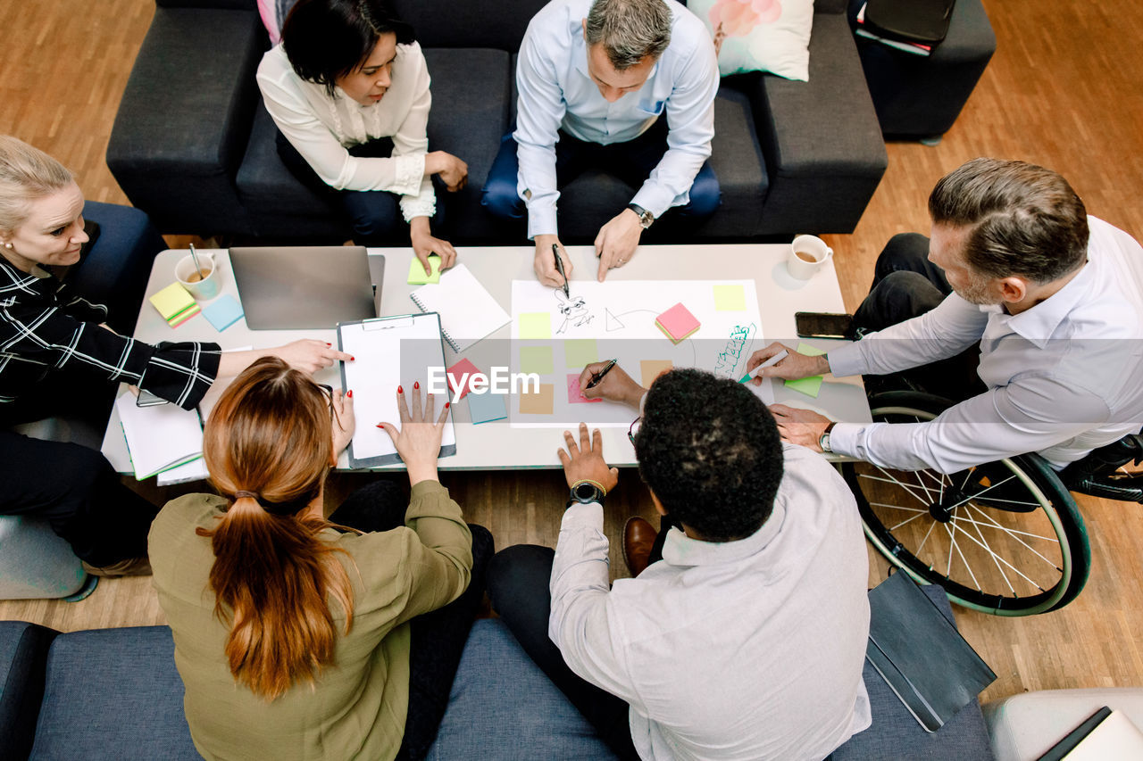 High angle view of sales executives planning business opportunities at work place