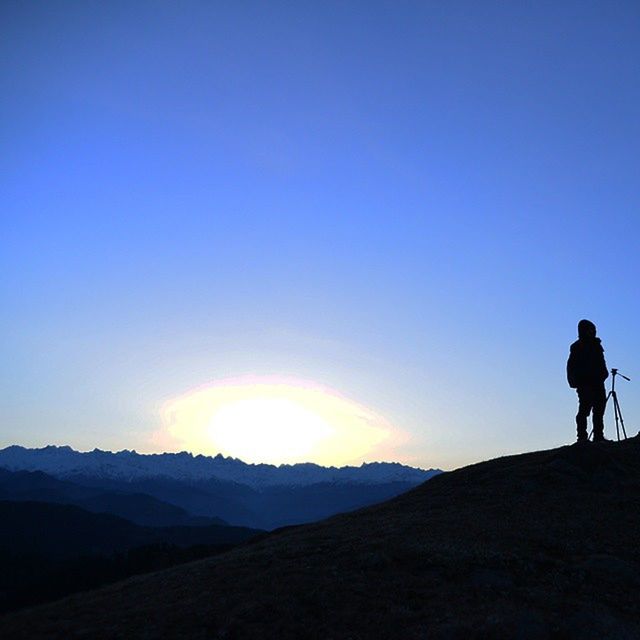 SILHOUETTE OF WOMAN STANDING ON MOUNTAIN