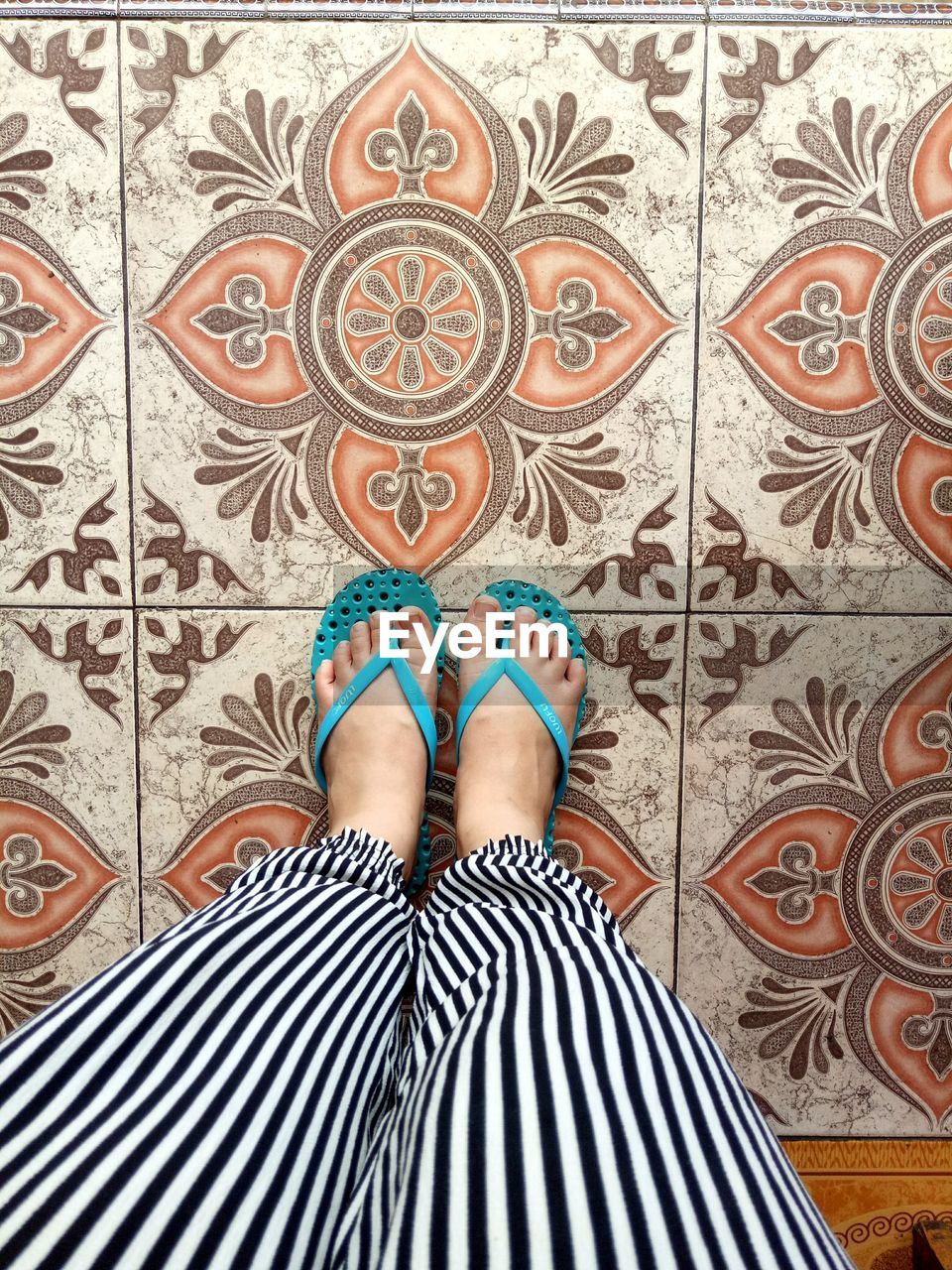 Low section of woman standing on tiled floor