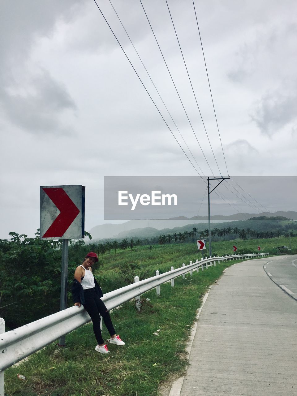 Rear view of man cycling on road against sky