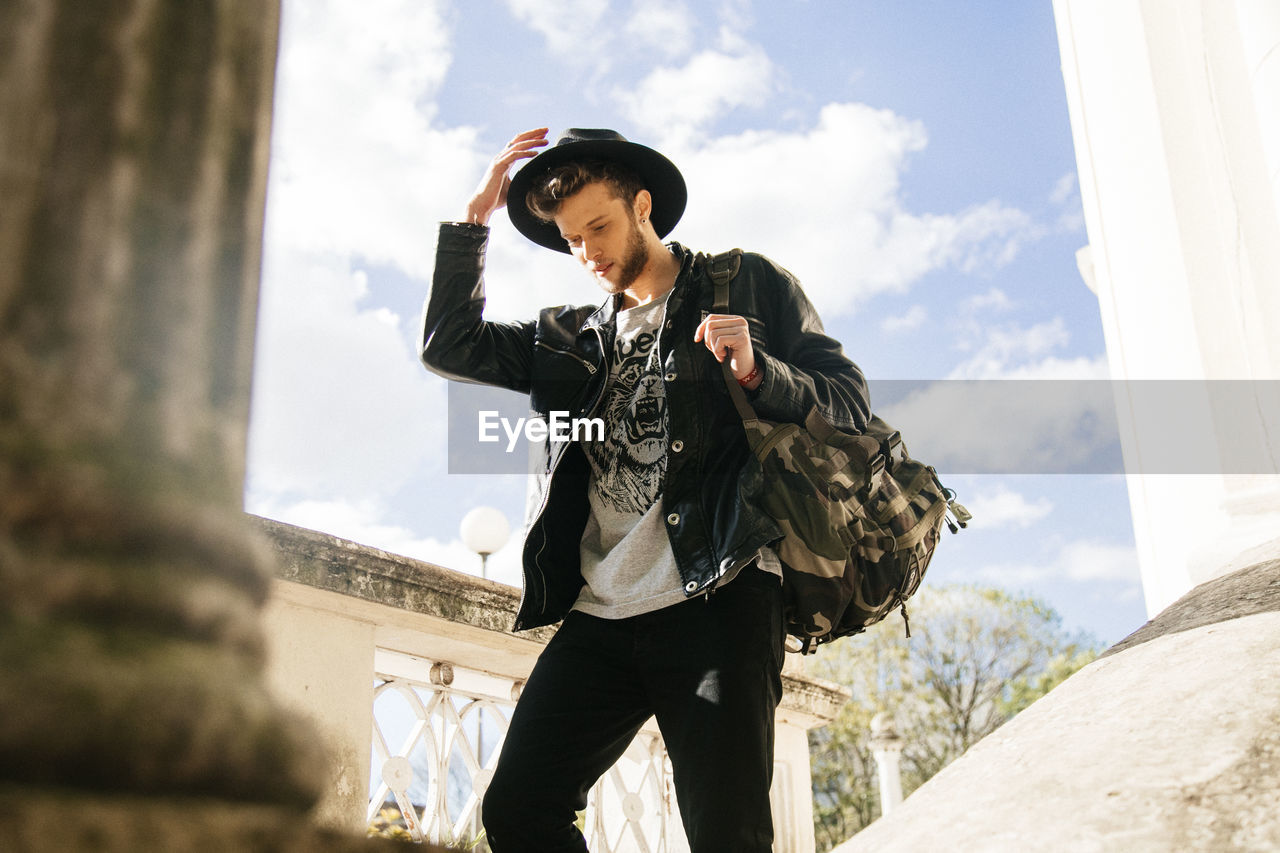 Low angle view of man walking against sky