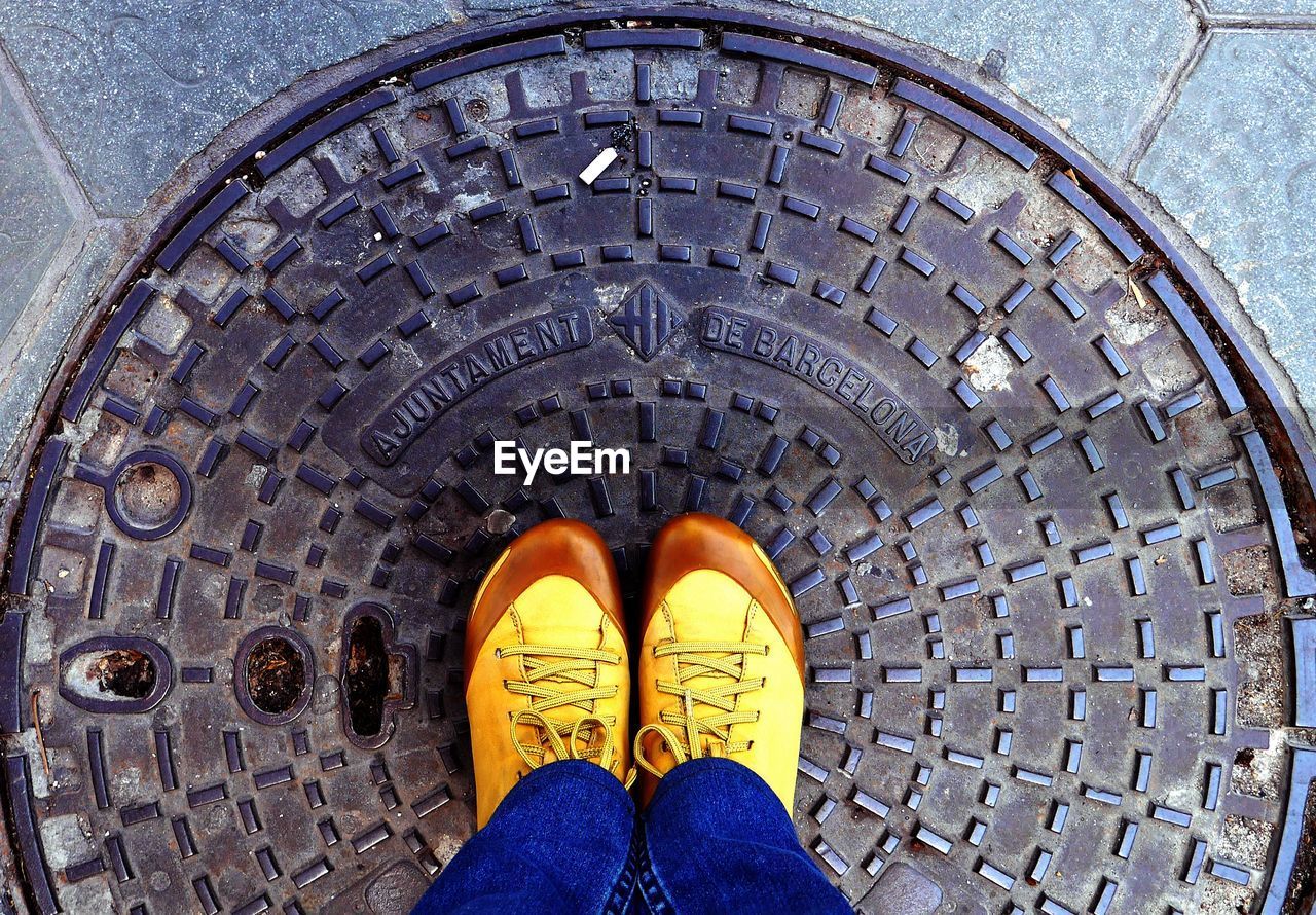 Low section view of man standing on manhole