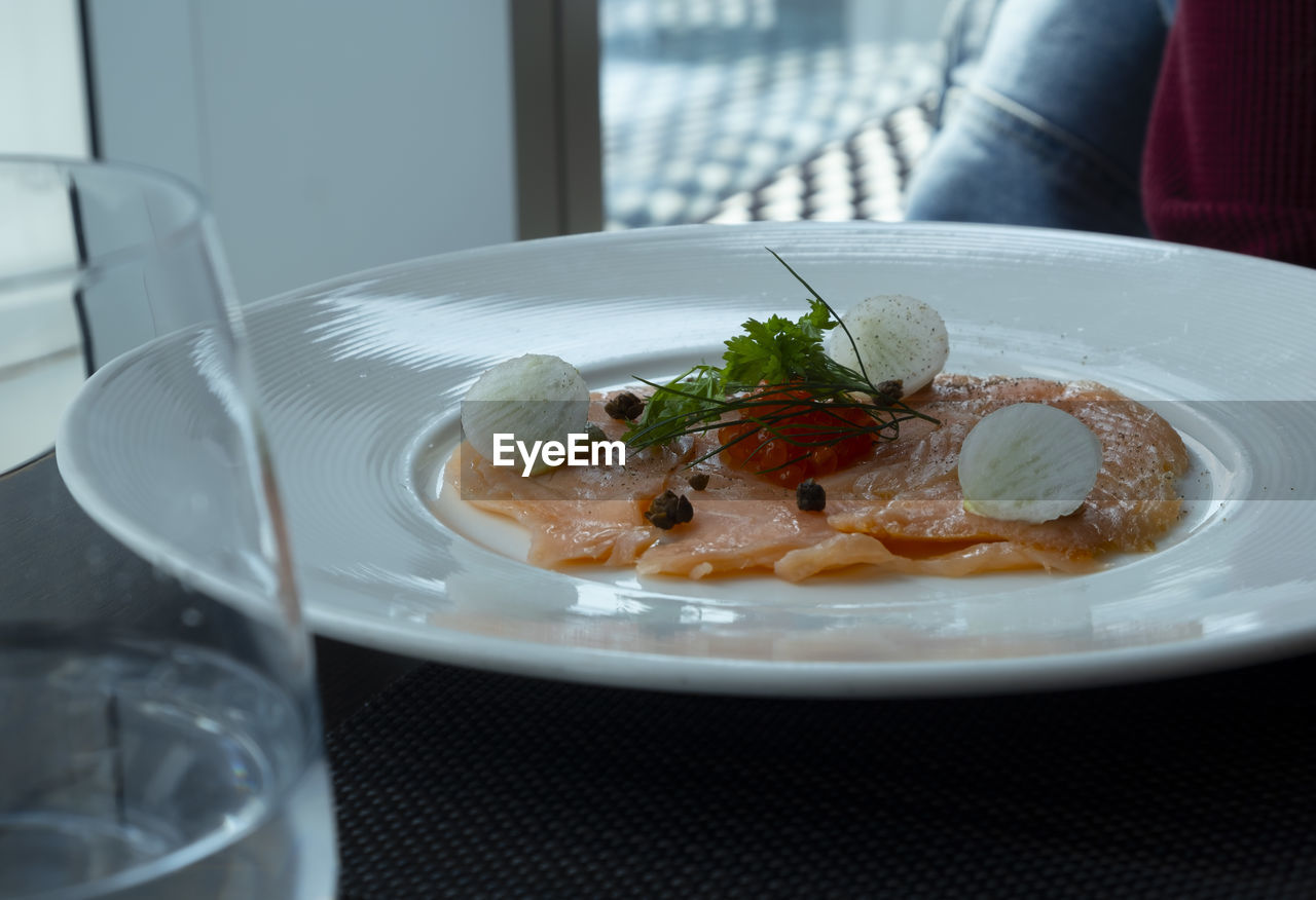 Smoke salmon on white plate in restaurant.