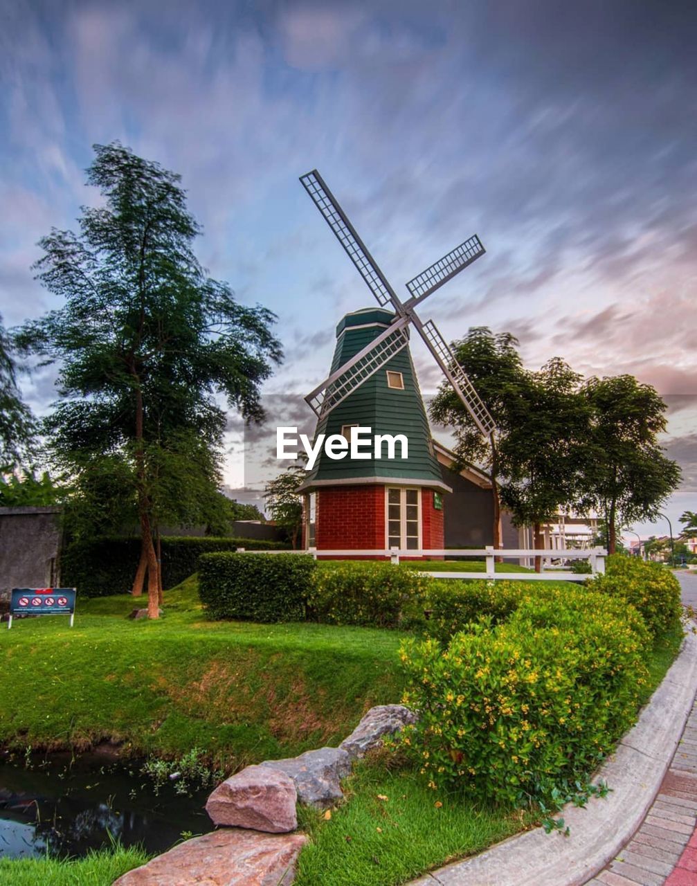 Traditional windmill by building against sky