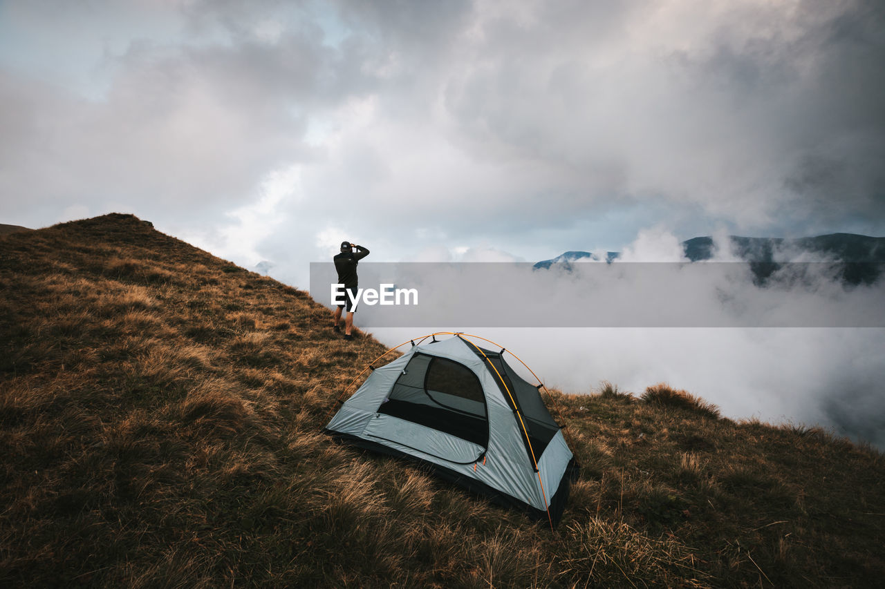 Photographer standing near the tent in the high mountains.fagaras mountains,romania