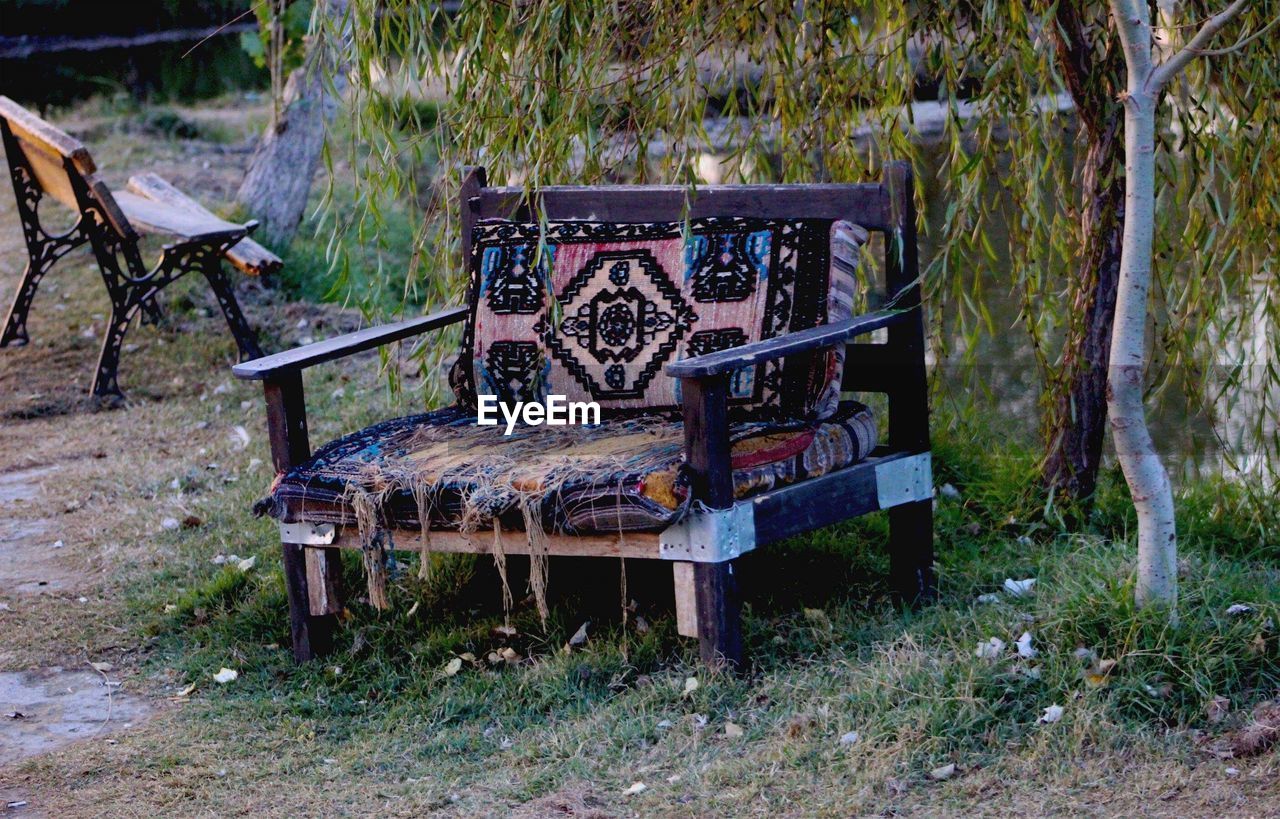 EMPTY BENCH ON TABLE BY TREES IN PARK