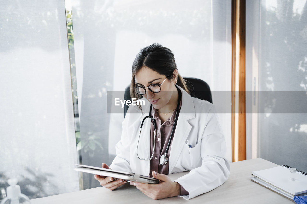 Female medical expert looking at digital tablet in medical clinic