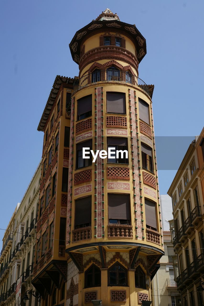 LOW ANGLE VIEW OF BUILDINGS AGAINST BLUE SKY