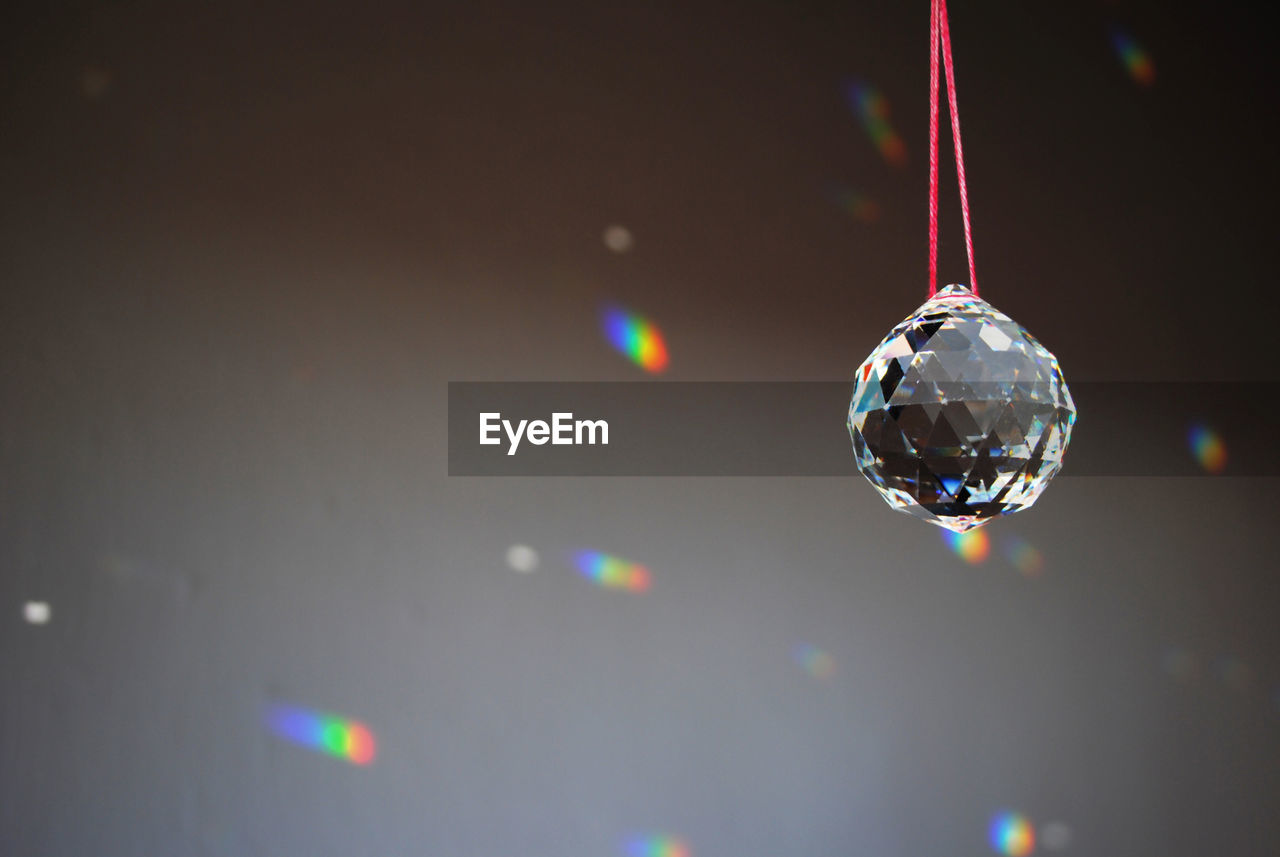 Close-up of crystal ball hanging against wall