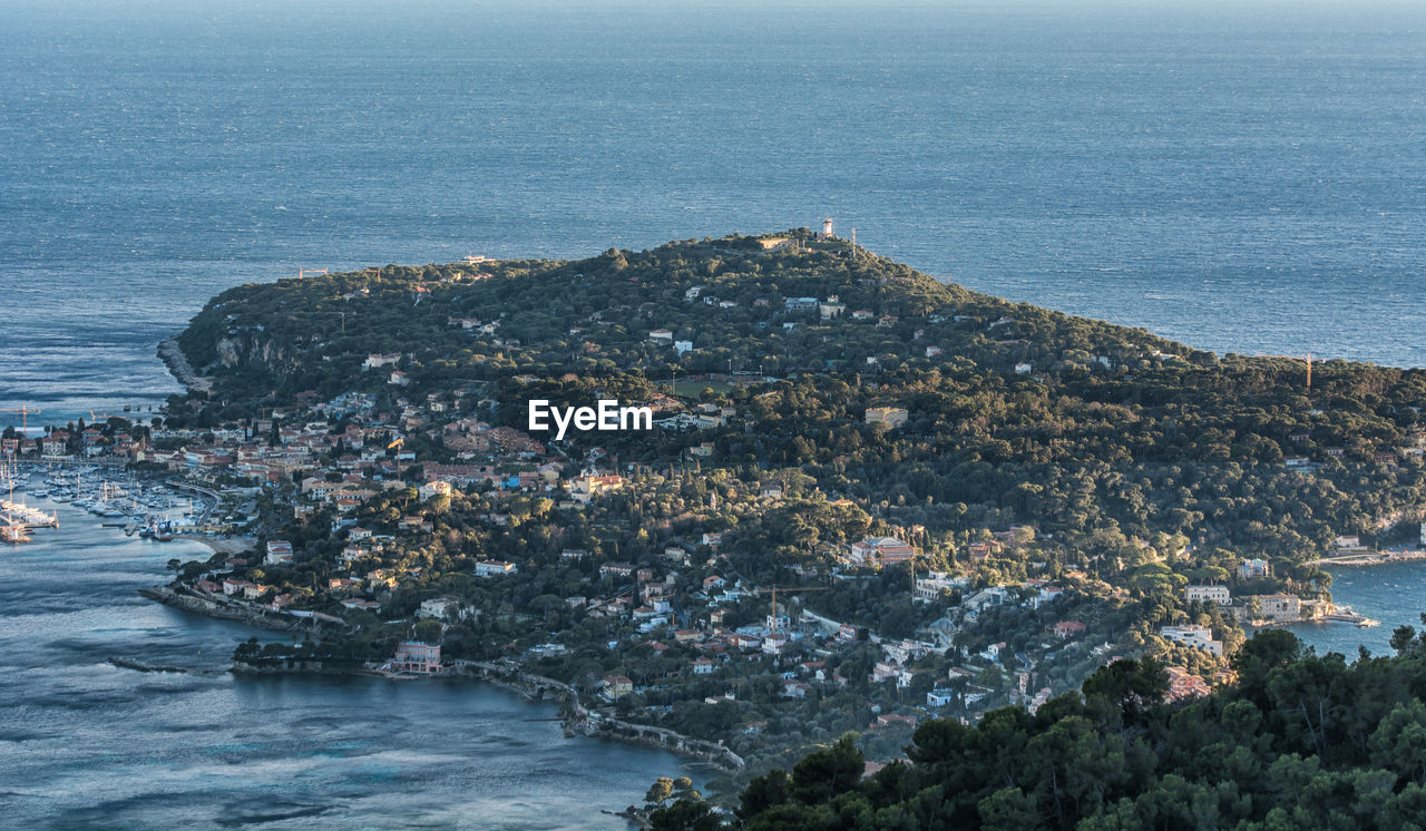 High angle view of townscape by sea against sky