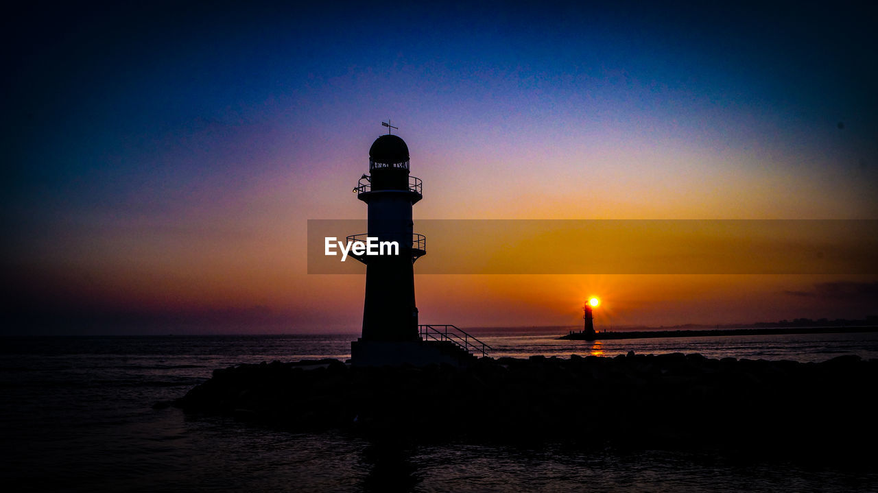 LIGHTHOUSE BY SEA AGAINST SKY AT SUNSET