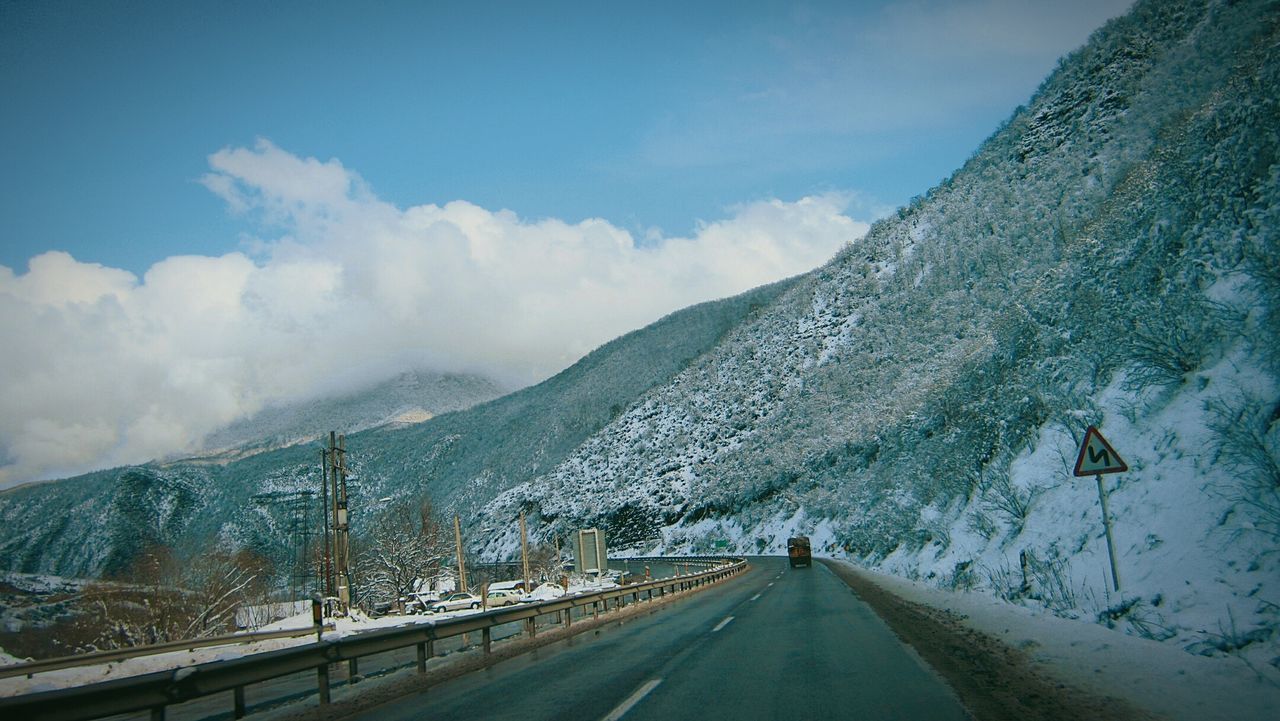 Road along snowcapped mountains against sky