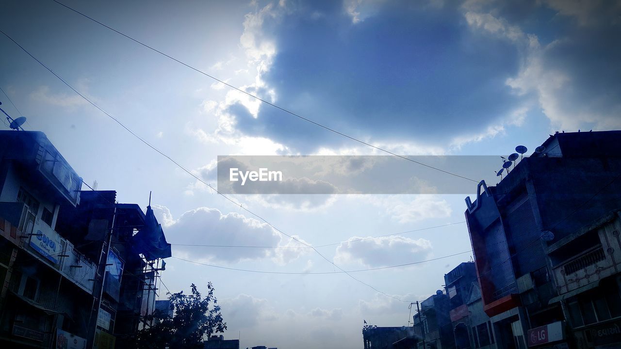 LOW ANGLE VIEW OF BUILDINGS AGAINST CLOUDS