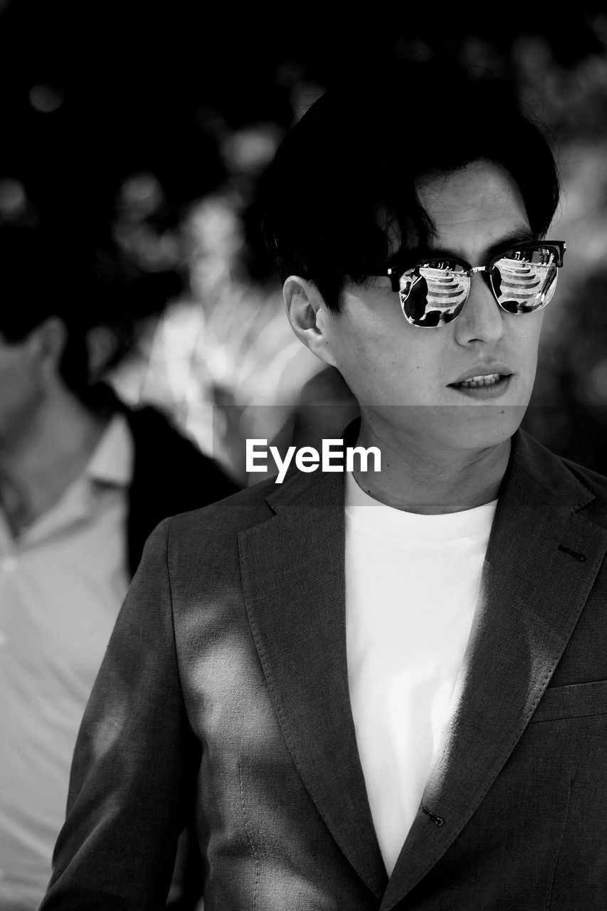 CLOSE-UP PORTRAIT OF YOUNG MAN WEARING SUNGLASSES