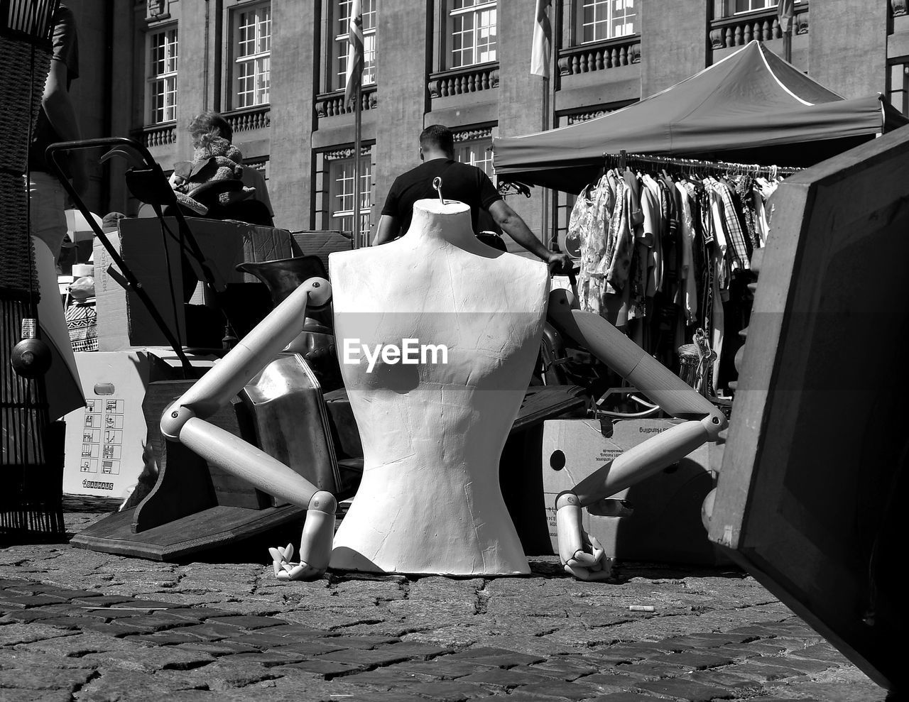 rear view of woman sitting on street in city