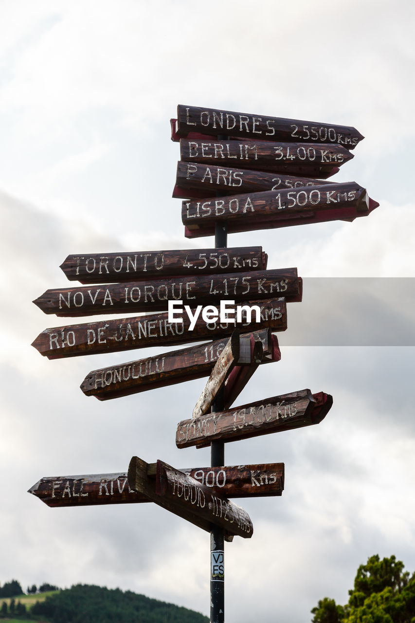 Low angle view of information sign against sky