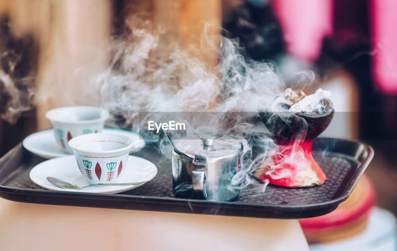 CLOSE-UP OF COFFEE CUP ON TABLE AT HOME