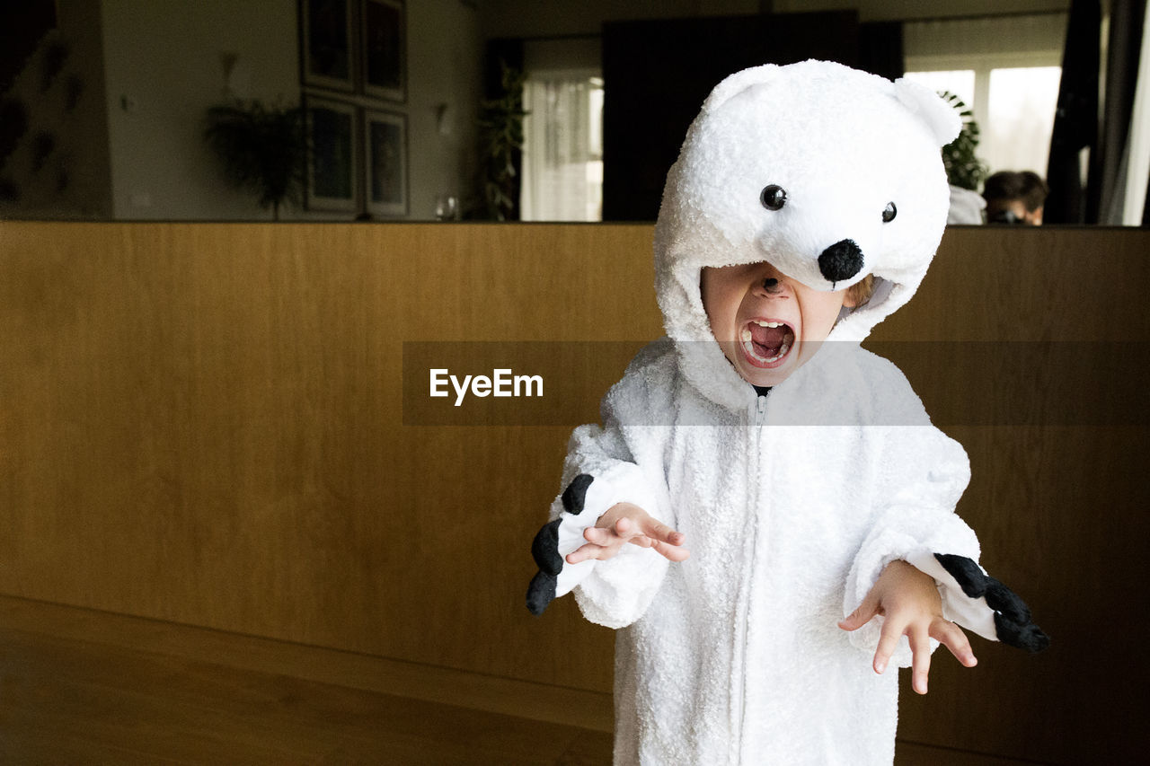Boy wearing polar bear costume at home