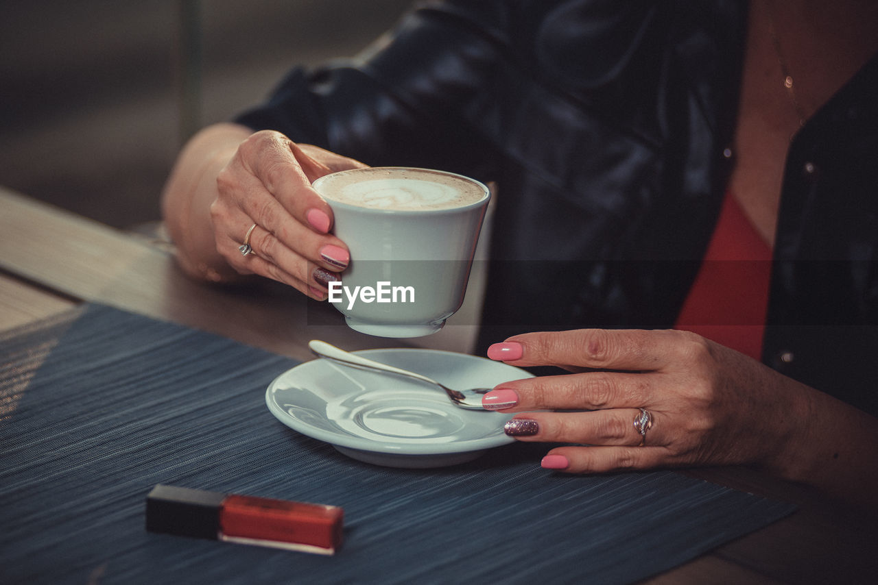 Woman is about to drink a cappuccino