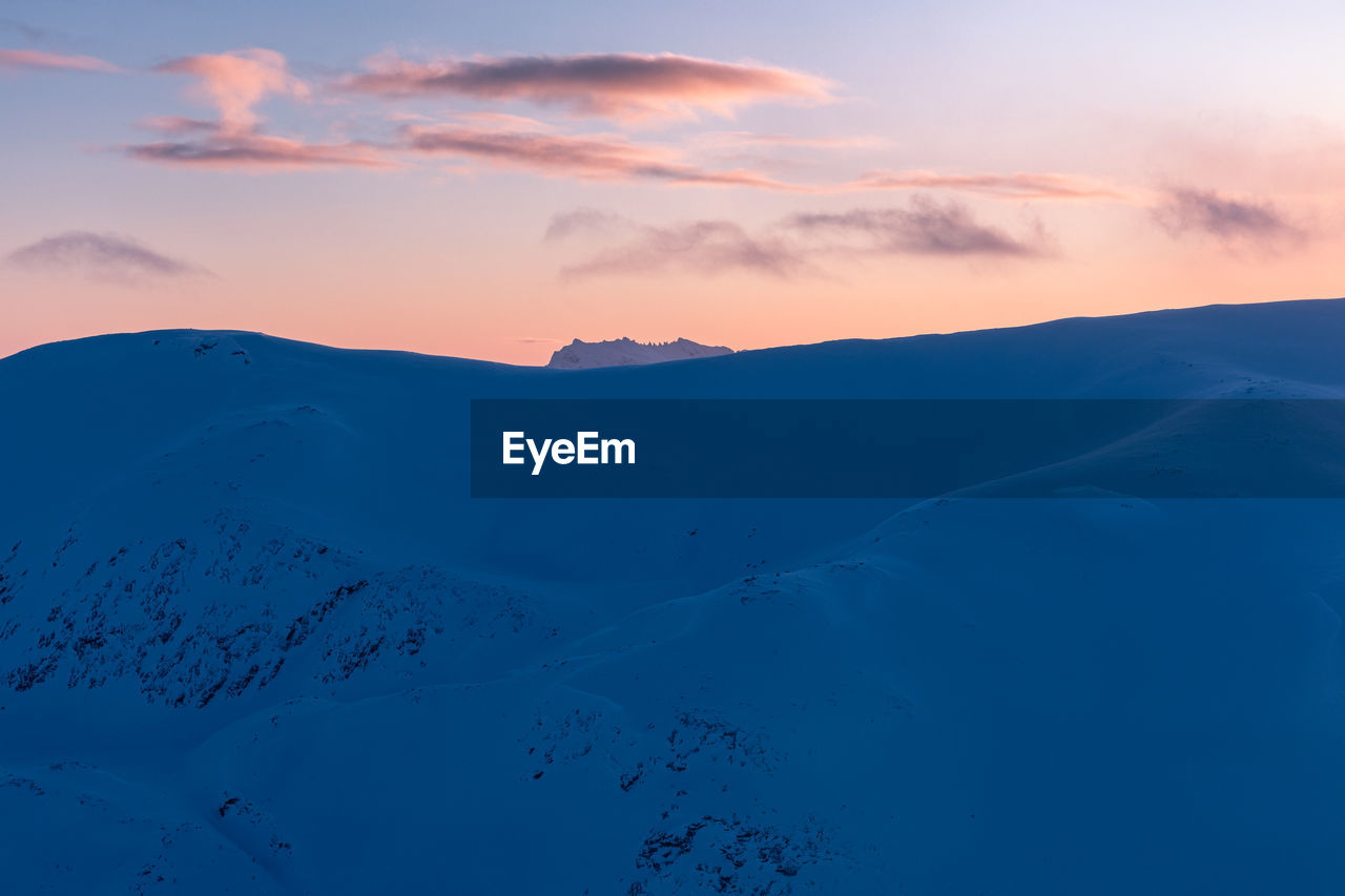 Scenic view of snowcapped mountains against sky during sunset