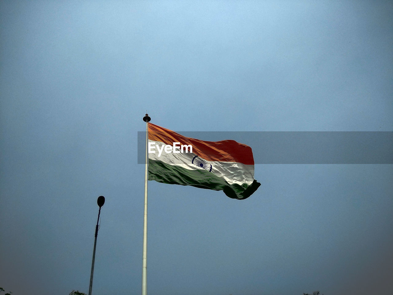 Low angle view of indian flag against blue sky