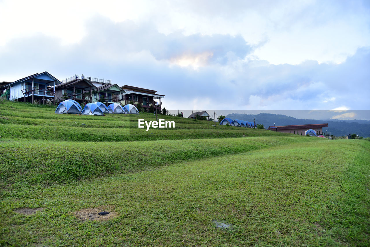 Houses on field against sky