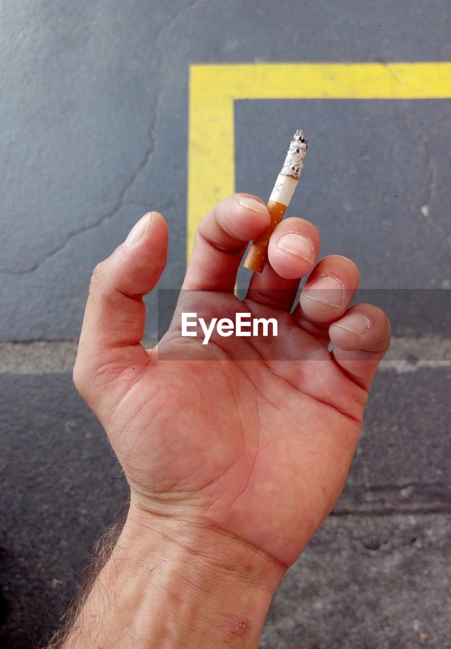 Close-up of hand holding cigarette