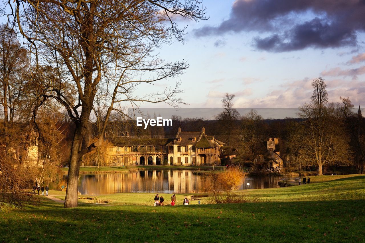 Buildings by lake against sky