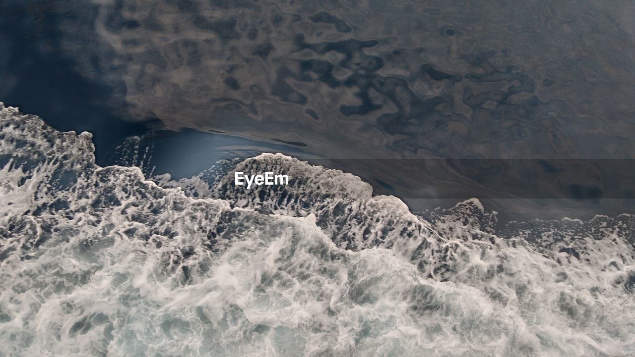 HIGH ANGLE VIEW OF ROCKS ON SEA SHORE