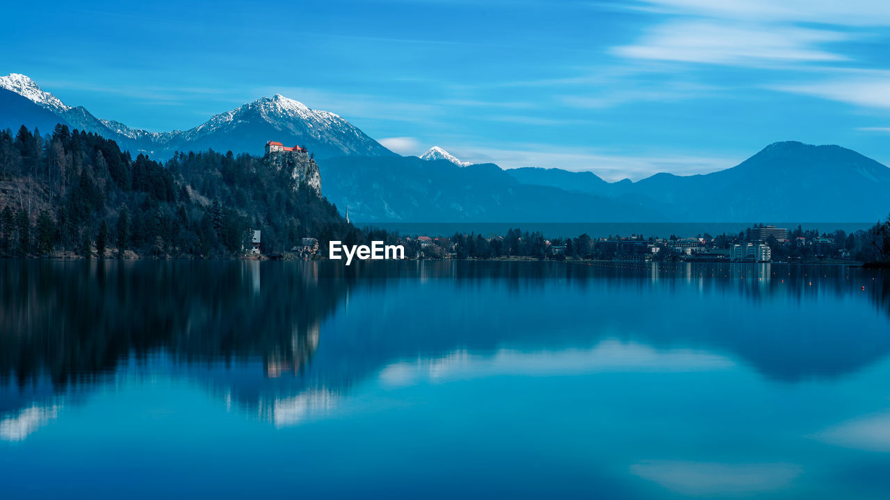 Scenic view of lake by mountains against sky