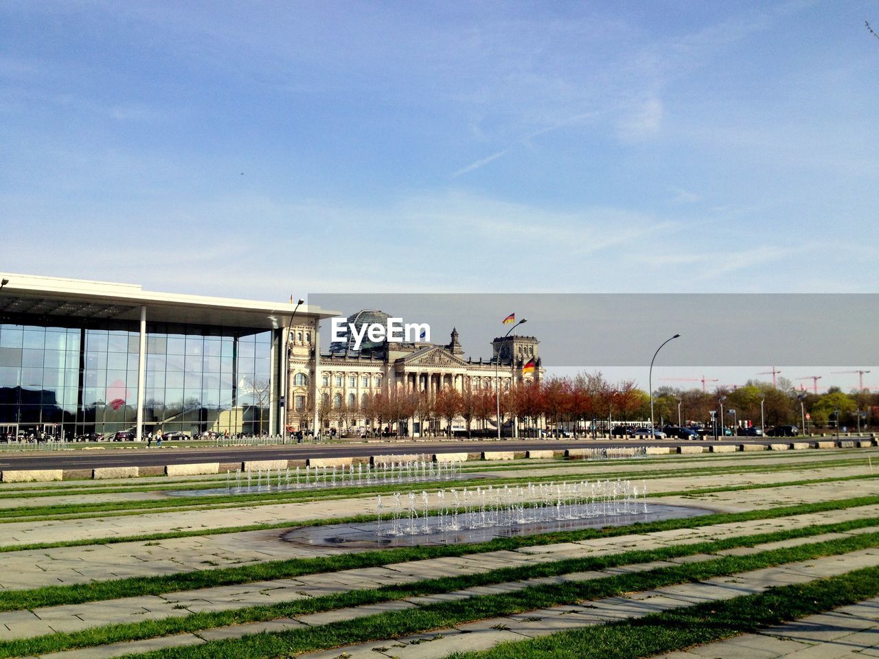 Fountain by bundestag against sky in city