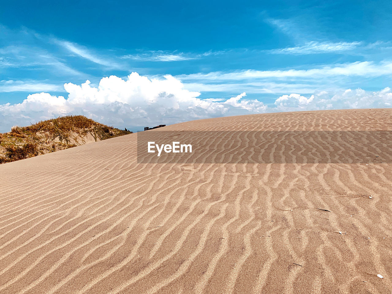 Sand dunes in desert against sky