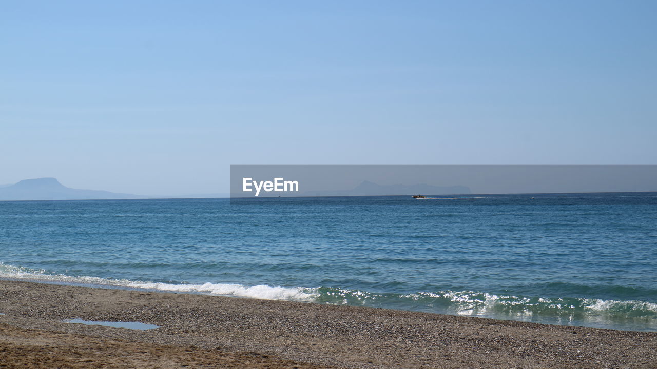 sea, water, sky, beach, land, horizon, body of water, scenics - nature, ocean, beauty in nature, shore, nature, horizon over water, tranquility, tranquil scene, coast, blue, clear sky, wave, travel, day, no people, travel destinations, sand, vacation, copy space, outdoors, idyllic, motion, tourism, bay, wind wave, coastline, non-urban scene, sunny, transportation, environment, holiday, seascape, trip, nautical vessel