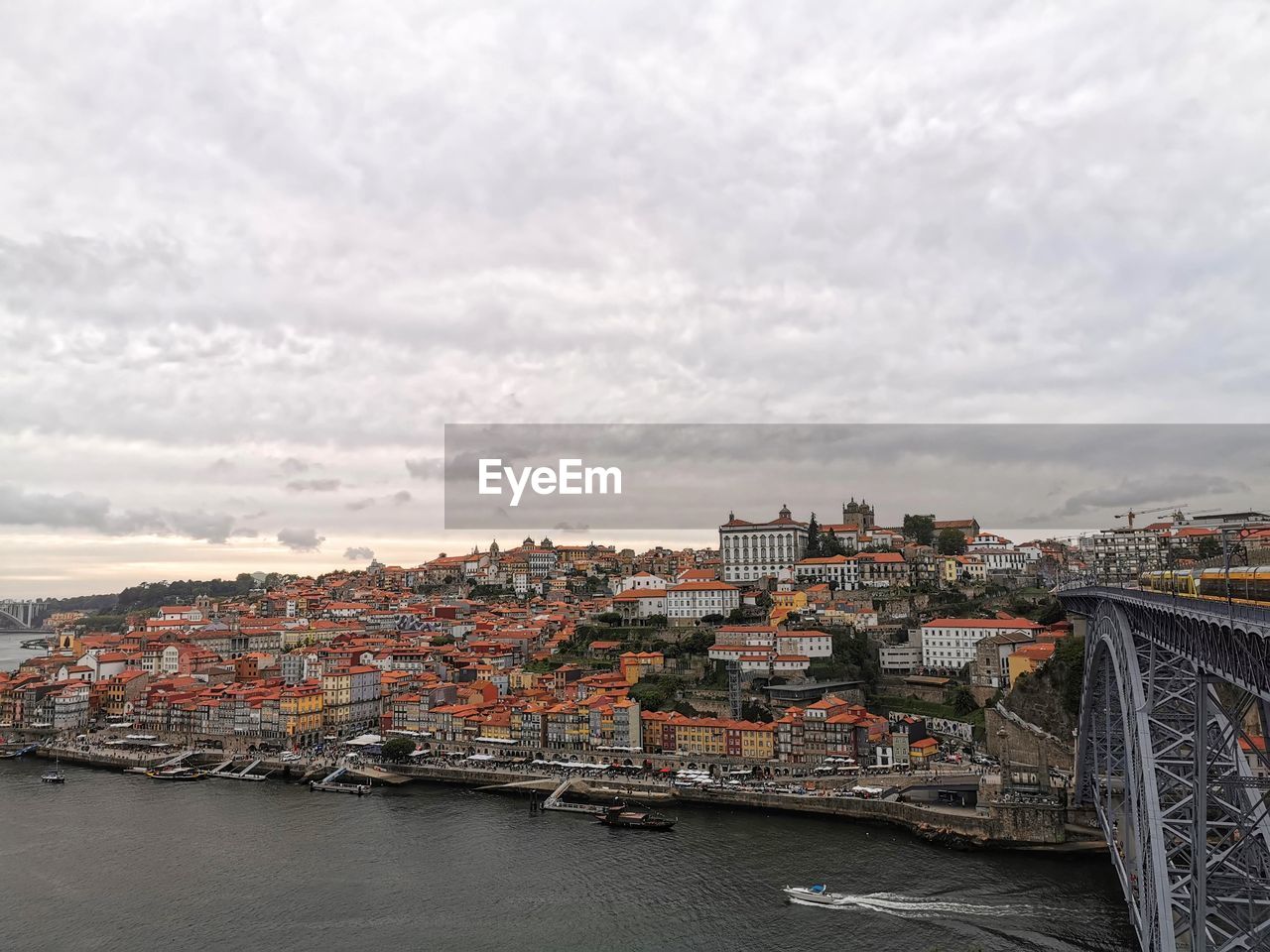 River amidst buildings in city against sky