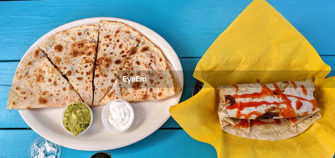 High angle view of burrito and quesadilla on a blue table