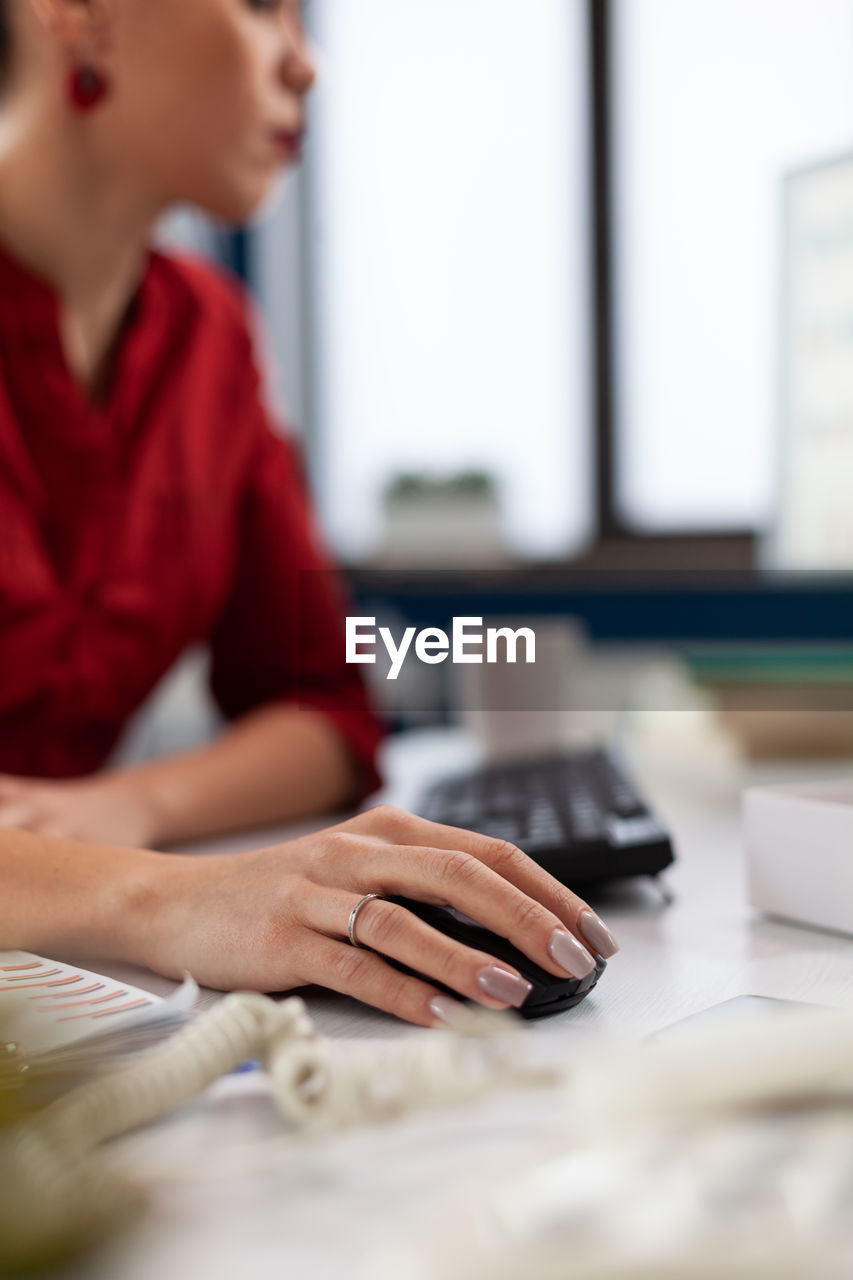 side view of businesswoman using laptop at table