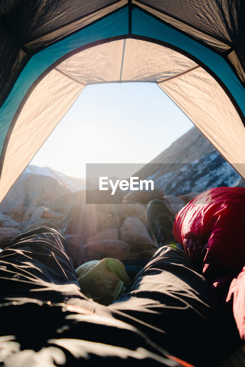 PORTRAIT OF WOMAN LYING DOWN ON MOUNTAIN