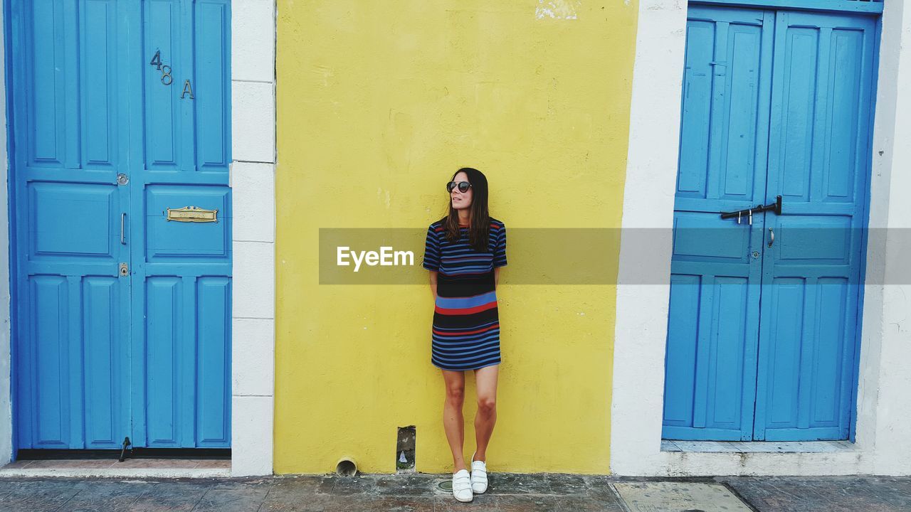 Woman standing against wall in city