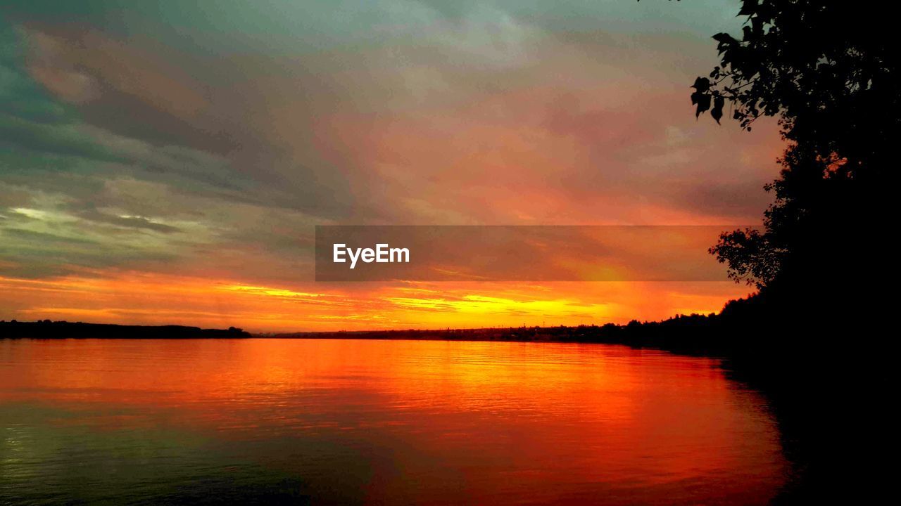 SCENIC VIEW OF LAKE AGAINST ORANGE SKY DURING SUNSET